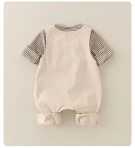 Detail eines Baby-Baumwollsets mit gestreiftem Oberteil und beiger Latzhose für Kleinkinder