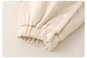 Nahaufnahme der beigen Babykleidung aus Baumwolle mit Twill-Struktur und Druckknöpfen