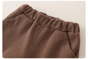 Dettaglio dei pantaloni in maglia marrone per neonato con elastico in vita e tessuto morbido