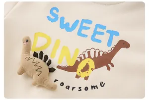 Detail eines Baby-Baumwoll-Sweatshirts mit 3D-Dinosaurier-Puppe und Sweet Dino-Aufdruck