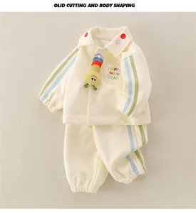 Detail of baby cream tracksuit featuring 3D caterpillar and Happy New Year embroidery