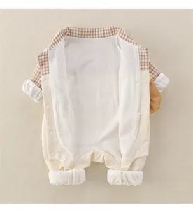Detail of baby romper featuring snap buttons and classic yellow plaid lining trim
