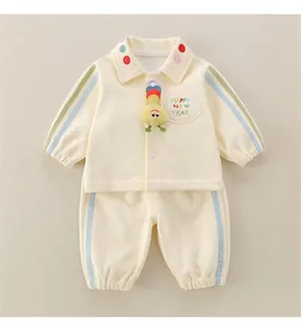 Detail of baby fleece tracksuit with colorful polka dots and 3D plush caterpillar toy