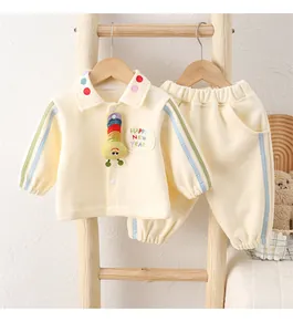 Detail of baby autumn polo set featuring 3D caterpillar toy and colorful polka dot collar