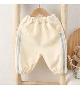 Detail of cream white baby trousers with light blue side stripes and elastic cuffs
