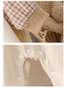 Detail view of cotton baby romper featuring plaid cuffs and resin snap buttons on the crotch