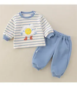 Detail of infant cotton set with striped long-sleeve top and blue pants featuring fried egg