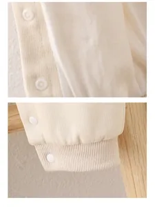 Close-up of soft cotton baby romper featuring secure resin snaps and ribbed sleeve cuffs