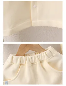 Close-up of cream waffle-knit baby outfit showing snap buttons and elastic waistband