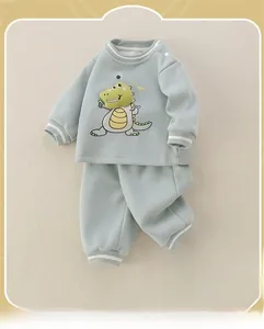 Detail of infant tracksuit showing mint green fabric with dinosaur patch and rib cuffs