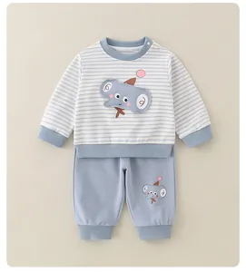 Macro detail of baby boy two-piece set featuring striped blue shirt and elephant embroidery