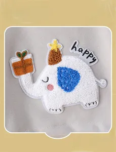 Macro detail of cartoon elephant towel embroidery on soft grey knit baby clothing
