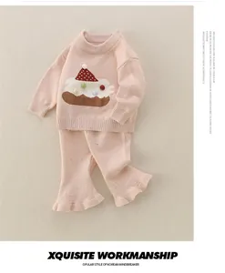 Details vom rosa Baby-Strickset mit Kuchenstickerei und ausgestellten Volantsäumen