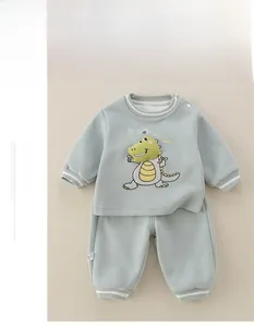 Detail of baby mint green tracksuit with 3D cartoon dinosaur and white striped cuffs