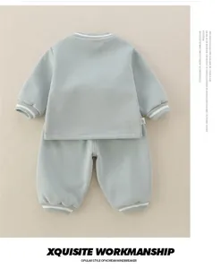 Detail of baby sage green sweatshirt set with ribbed striped cuffs and soft cotton texture