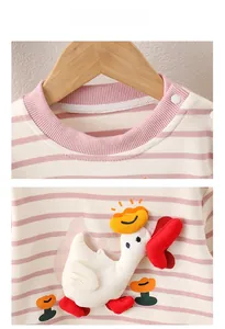 Detail of pink striped baby top with shoulder buttons and 3D cartoon swan applique