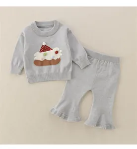 Detail eines hellgrauen Stricksets für Babys mit 3D-Stickerei und Rüschendetails an der Hose