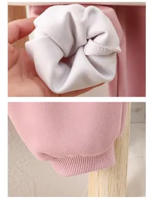 Detail of pink cotton baby set showing thick white fleece lining and ribbed cuffs