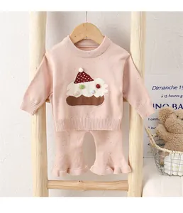 Detail eines rosa Stricksets für Babys mit 3D-Kuchendekoration und weichem Material