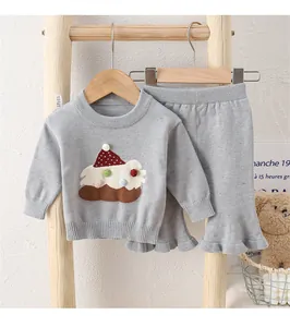 Detailaufnahme des Mädchen-Stricksets mit bunter Applikation und Rüschenhose