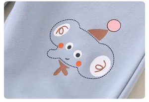 Close-up of baby boy outfit featuring soft blue cotton fabric and a cute cartoon print