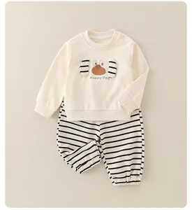 Détail du sweat-shirt en coton beige avec broderie chien et pantalon rayé pour bébé