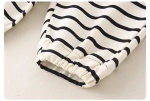 Gros plan des poignets élastiques sur un ensemble en coton rayé pour petit garçon