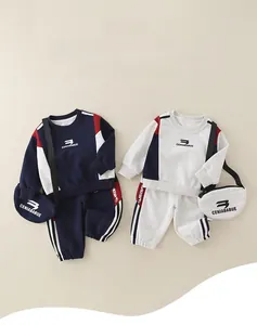 Detail of two-piece cotton toddler tracksuits in navy and grey with matching mini bags