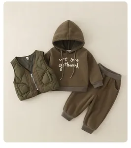 Dettaglio del set 3 pezzi per bambini con gilet trapuntato oliva e felpa marrone