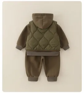 Dettaglio flat lay di un completo invernale da bambino tre pezzi con gilet e felpa