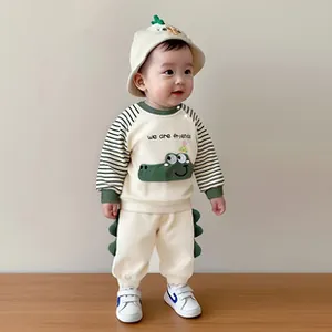 Detail of baby cotton set showing cartoon crocodile print and striped sleeves texture