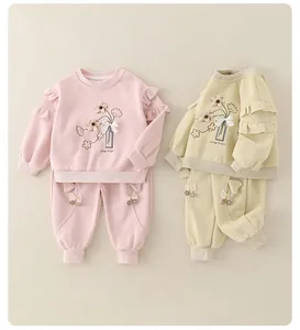 Detail of baby cotton sets featuring floral embroidery and 3D bow accents on sweatshirts