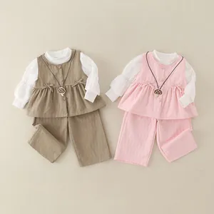 Detailed flat lay of baby cotton ruffle vest sets with mushroom charms in brown and pink