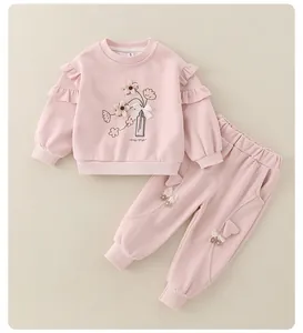 Detail of pink cotton toddler set featuring floral embroidery and ruffle shoulder trim