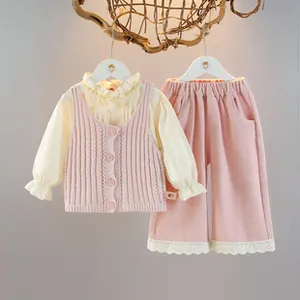 Detailed view of 3-piece baby girl outfit with beige ruffled shirt and pink knit vest