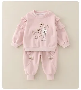 Detail of pink cotton baby set featuring 3D floral embroidery and ruffle shoulder accents