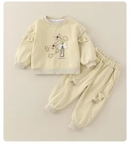 Detailed shot of baby cotton set featuring ruffle shoulders and floral embroidery