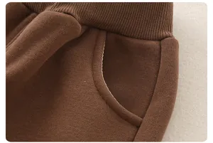 Dettaglio macro dei pantaloni in maglia di cotone marrone con vita elastica e cucitura tasca