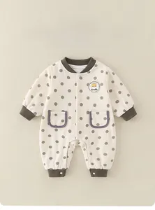 Detail of baby cotton romper with brown polka dots and giraffe embroidery patch