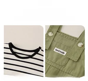 Detail of baby cotton striped shirt and green overalls with wooden buttons and hand made label