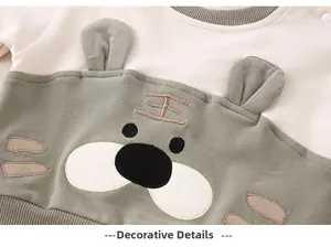 Exquisite detail of baby bodysuit showing soft cotton texture and tiger face embroidery