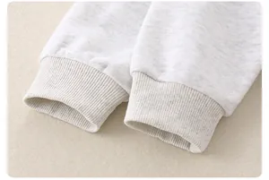 Close-up of light gray cotton fabric texture and ribbed cuff detail on infant clothing