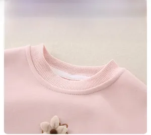 Detail of pink cotton baby sweatshirt showing ribbed neckline and 3D floral embroidery