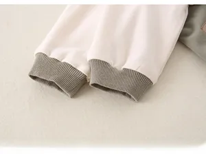 Macro detail of ribbed cotton cuffs on a baby romper with sage green color blocking