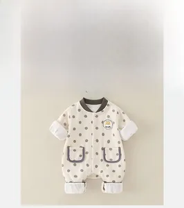 Close-up of baby romper featuring brown polka dots and a cute giraffe patch detail