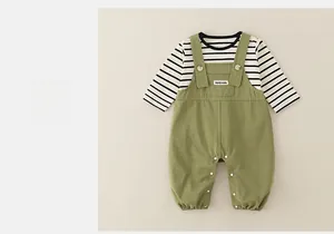 Detail of striped cotton baby shirt and olive green overalls with button snaps