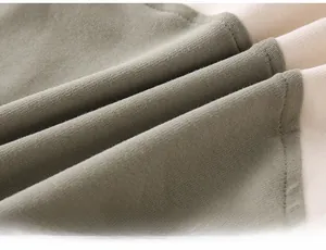 Close-up of baby romper fabric showing soft olive green and beige cotton with double stitching