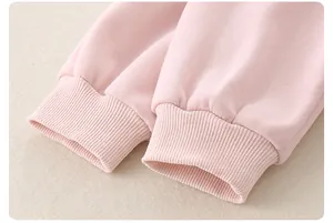 Detail of soft pink ribbed cuffs on a high-quality cotton baby sweater for spring