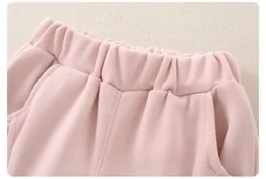 Detail of baby pink knitted cotton pants featuring elastic waistband and side pocket