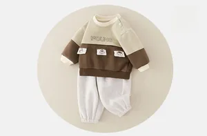 Detail of baby boy cotton set with color-block sweatshirt and animal pocket design